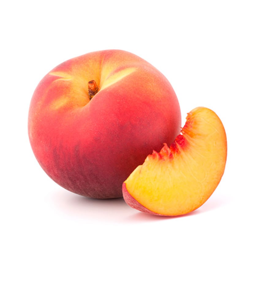 A peach is cut in half on a white background.