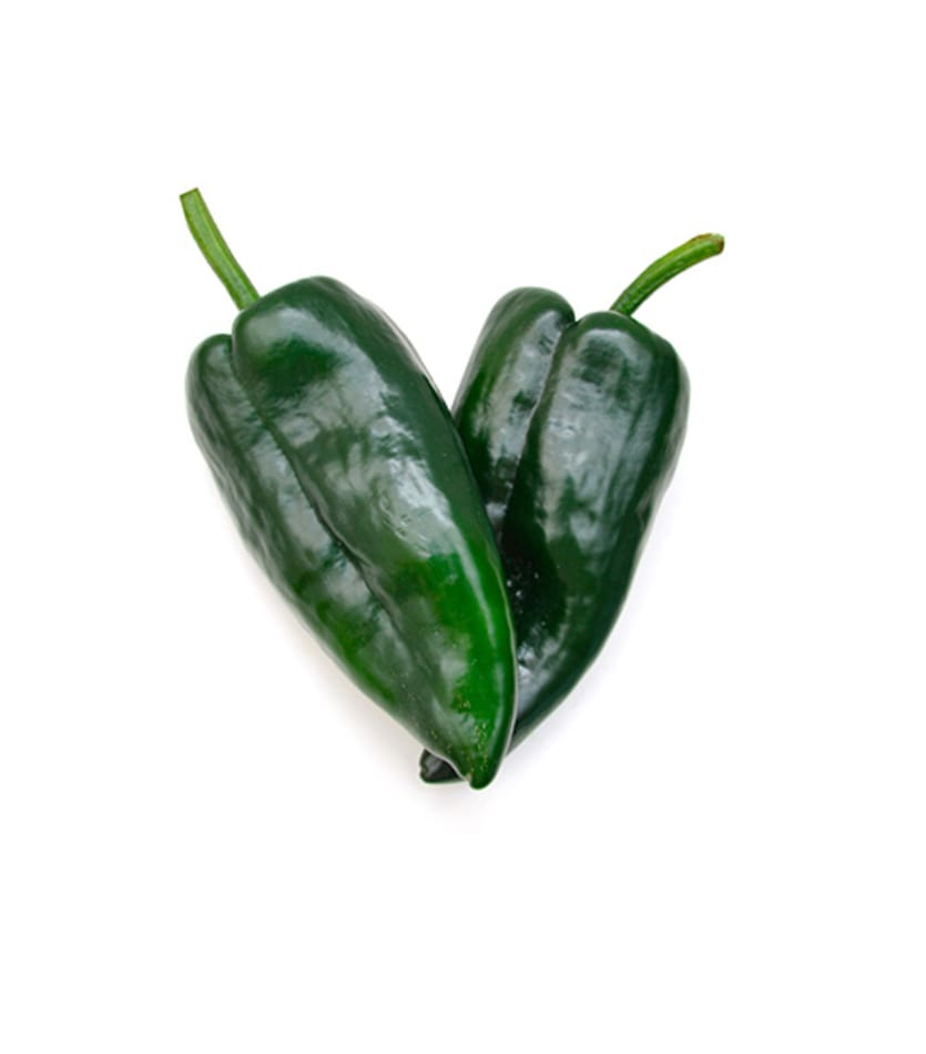 Two green peppers in a heart shape on a white background.